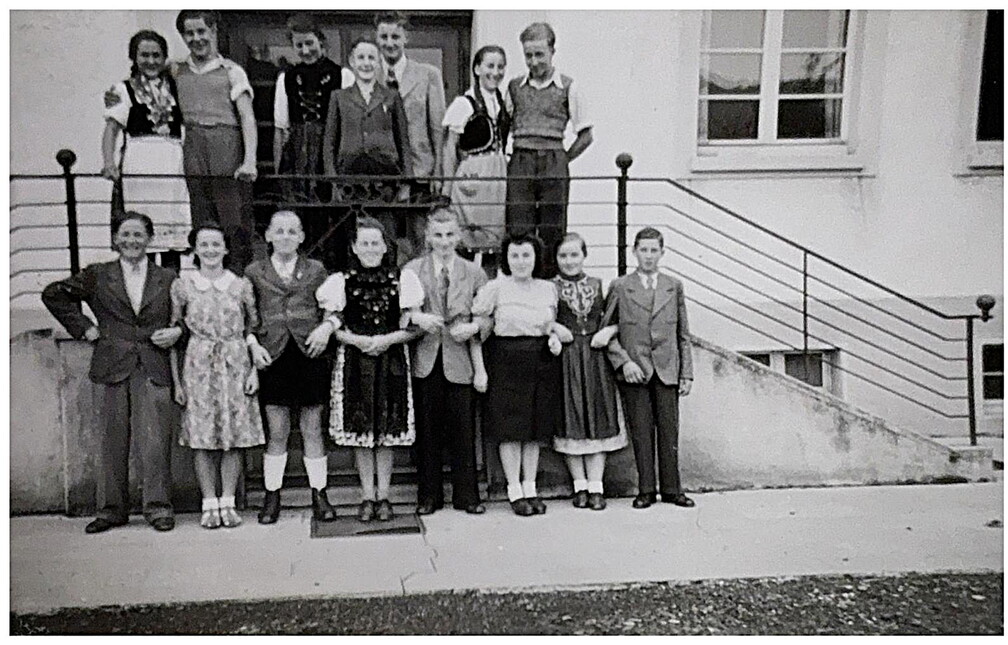 Eine Gruppe älterer Schüler posieren an der Schultreppe.