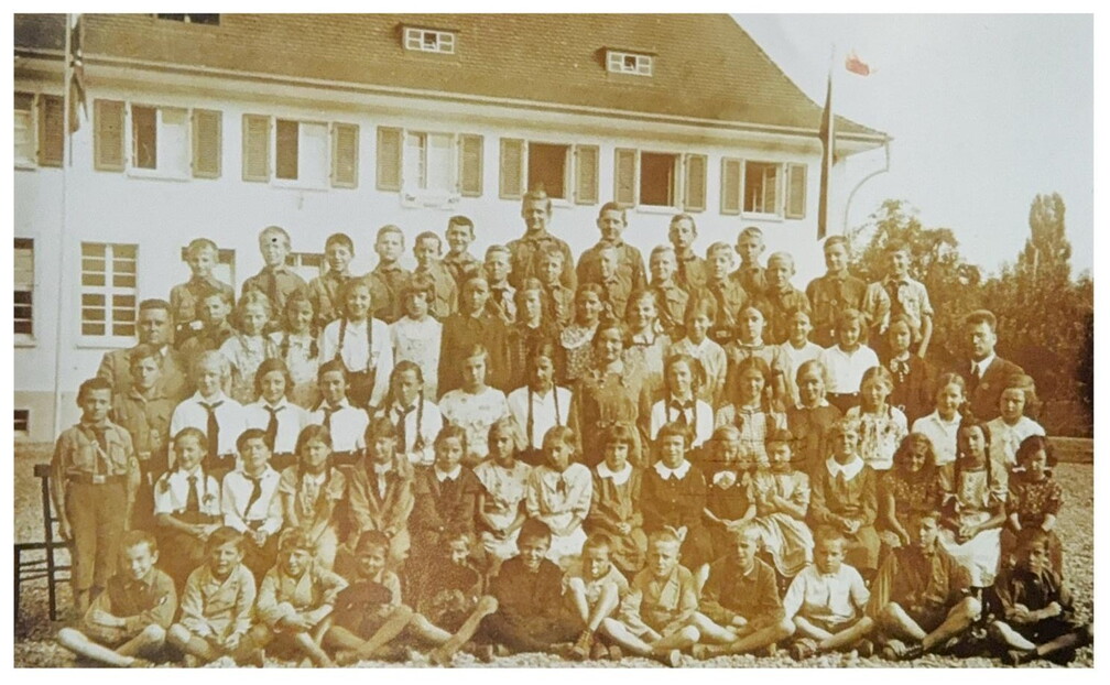 Gruppenbild von Hitlerjungen und Jungmädchen vor der Schule. Lehrer Albrecht am linken Rand. 1936