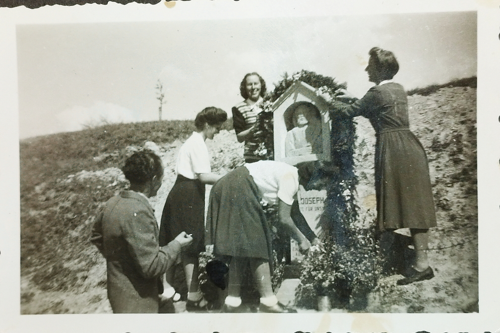 Frauen schmücken den Gedenkstein an  der Eisenbahnstrasse Richtung Bahnhof. Ungefähr 1950